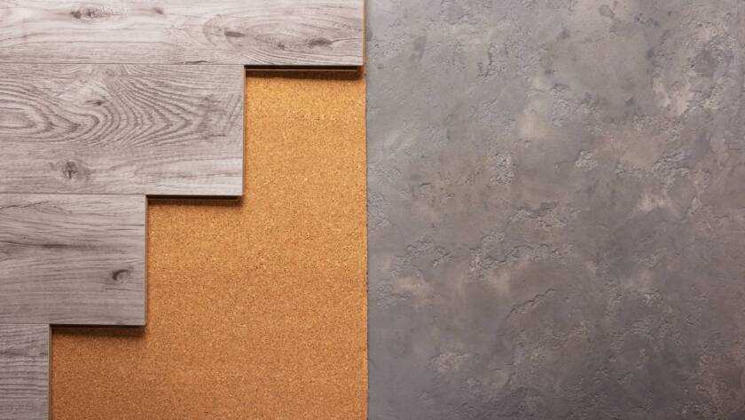 Laminate wood floor at cork background texture. Wooden laminate floor and corkboard on cemen